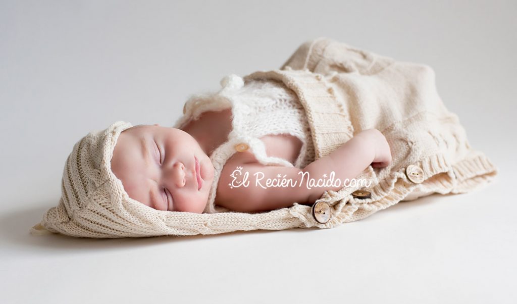 Fotografía newborn Madrid, niño dormido sobre arrullo con capa hecho a mano. Fotógrafo recién nacidos y bebes en Madrid